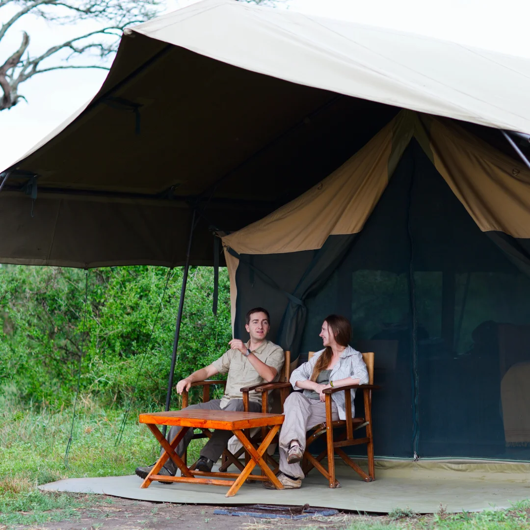 Couple sitting outside safari tent.