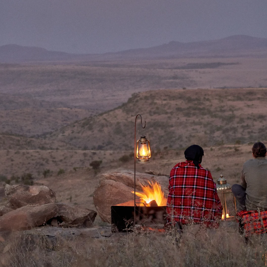 Campfire on a hillside at dusk.