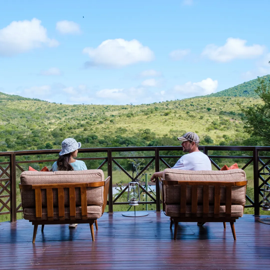 Couple on a balcony overlooking hills.