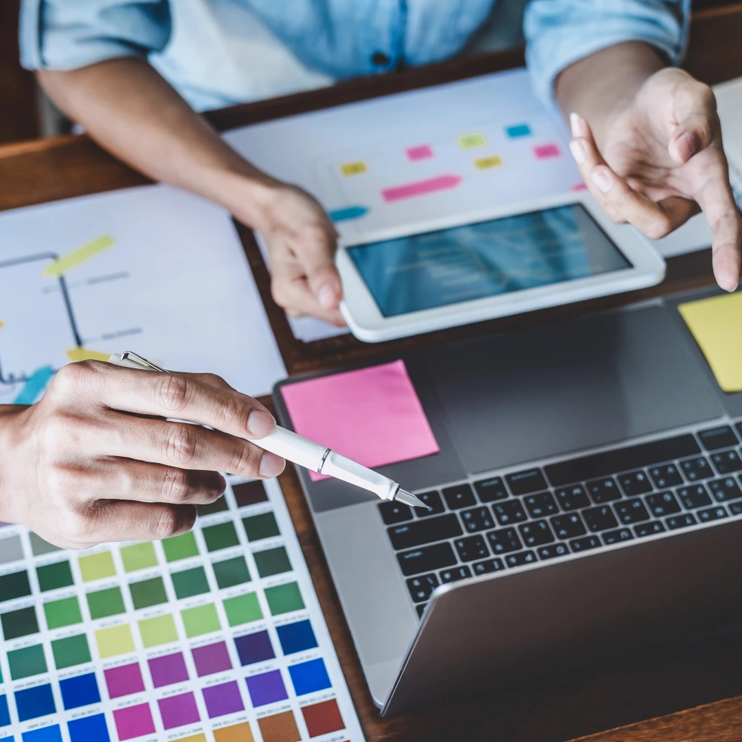 Designers working with laptop and color palette.
