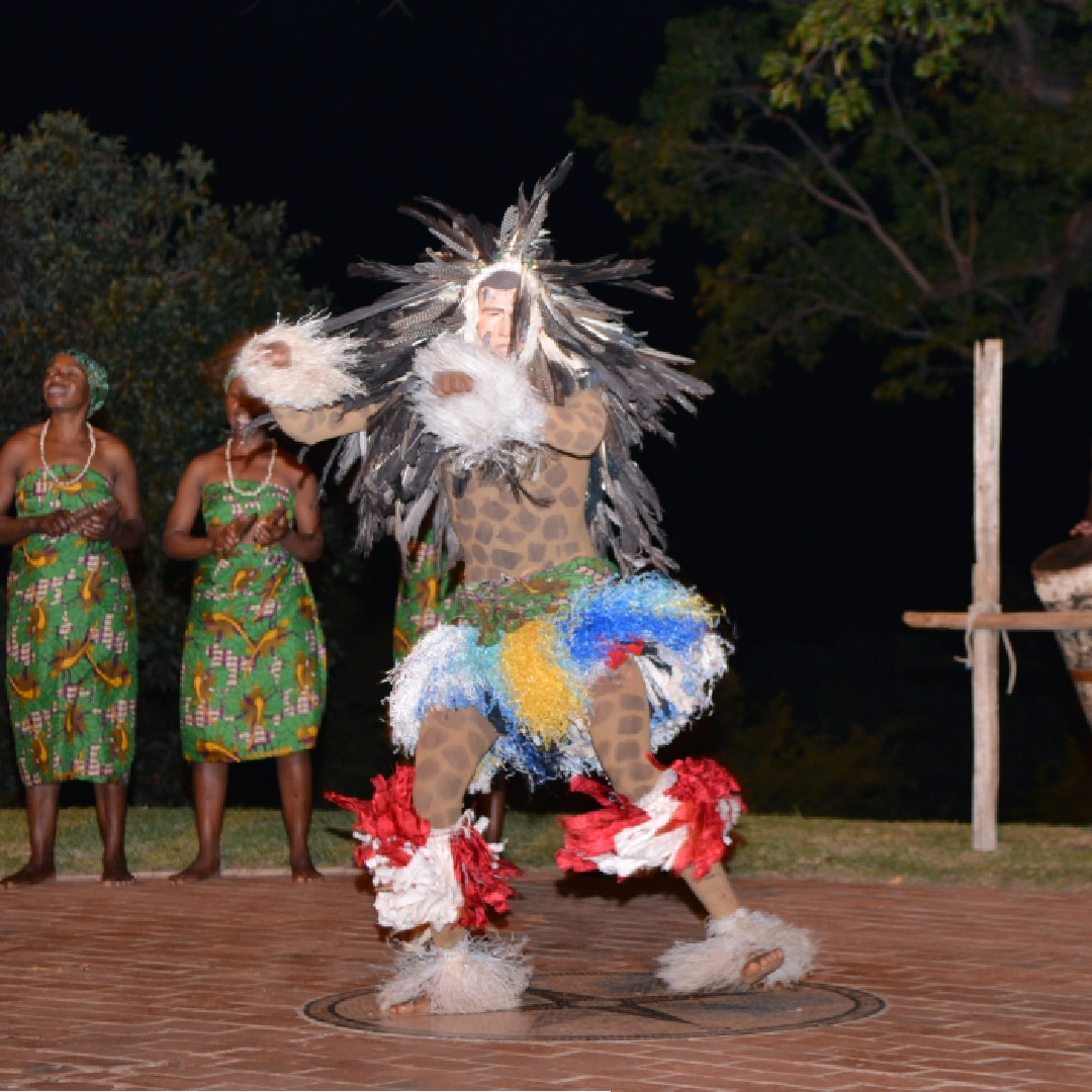 Traditional dancers performing outdoors at a historic hotel.